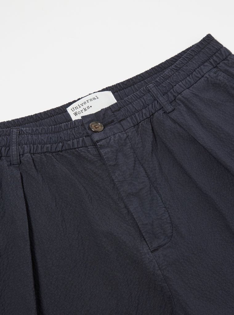 UNIVERSAL WORKS PLEATED TRACK SHORT II SEERSUCKER - NAVY